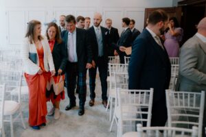 People dressed formally walking into event venue.