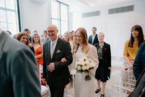 Bride walking down the aisle, smiling.
