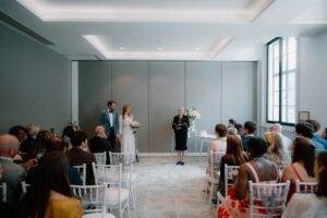 Couple getting married in front of guests indoors.