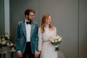 Smiling couple holding hands at wedding ceremony.