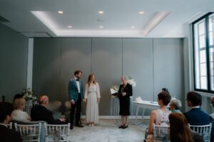 Wedding ceremony with couple and officiant indoors.