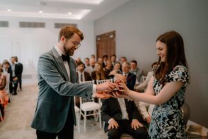 Smiling couple exchanging rings during ceremony
