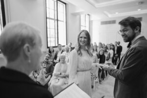 Couple exchanging rings in wedding ceremony.