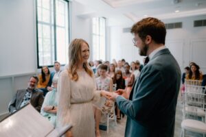 Bride and groom exchanging rings at wedding ceremony.