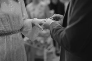 Close-up of couple exchanging wedding rings.