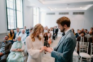 Bride and groom exchanging rings at wedding ceremony.