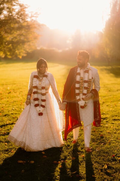Couple in traditional attire walking at sunset.