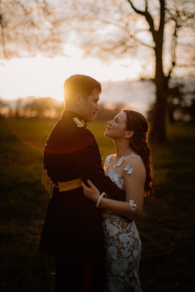 Couple embracing at sunset in a field.
