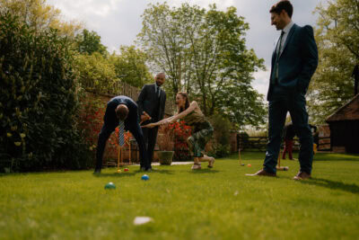 People playing croquet on a sunny garden lawn.
