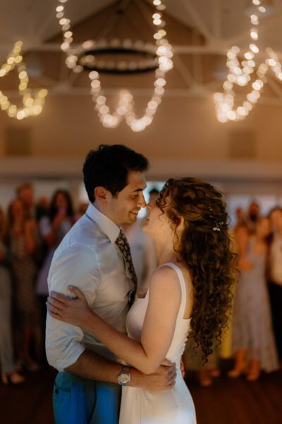 Couple dancing at wedding under fairy lights.