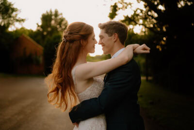 Couple embracing outdoors with evening light.