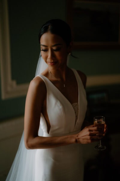 Bride in elegant gown holding champagne glass