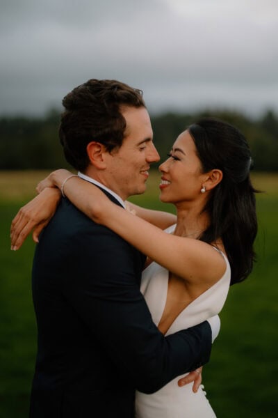 Couple embracing outdoors on their wedding day.
