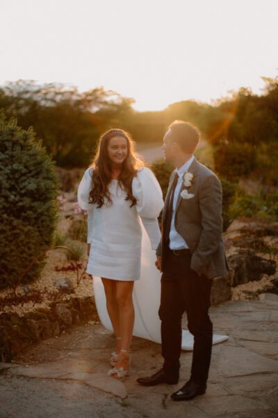 Couple smiling at sunset outdoors.