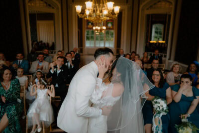 Bride and groom kissing during wedding ceremony.