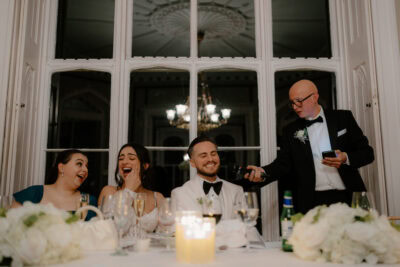 Wedding speech with guests laughing and smiling.