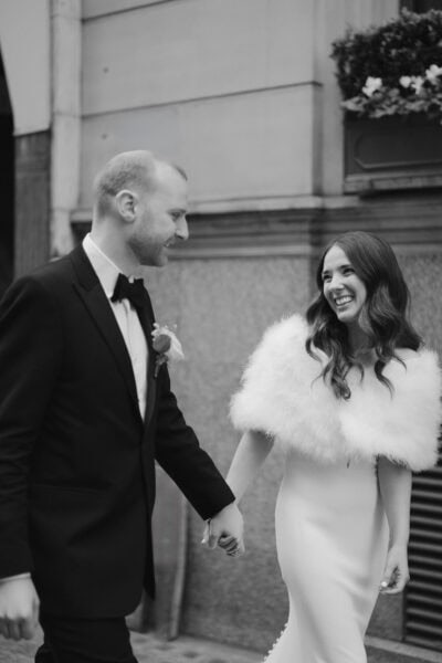 Smiling couple holding hands at wedding.