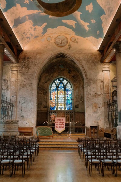 Wedding venue with vintage chairs and stained glass.