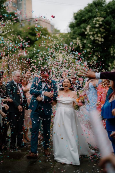 Wedding couple showered with confetti celebration.