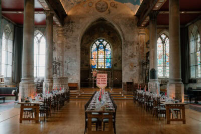 Elegant historic building with long banquet tables.
