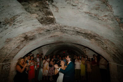 Couple dancing at wedding in historic cave venue.