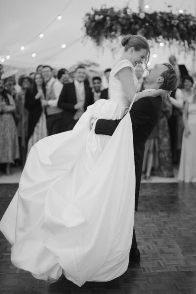 Bride and groom dancing joyfully at wedding reception.