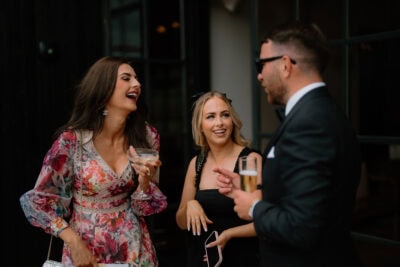 Three people laughing at a social event