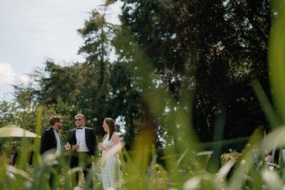 Garden party attendees enjoying drinks and conversation.
