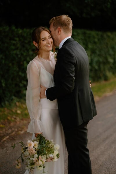Bride and groom embracing with flowers