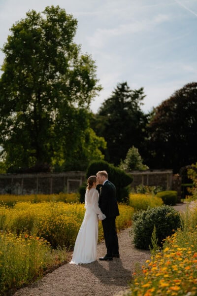 Bride and groom kiss in blooming garden
