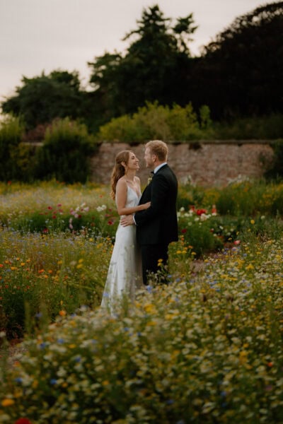Couple embracing in a colourful flower garden.