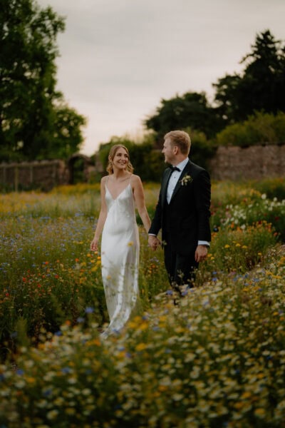 Couple walking in flower-filled garden