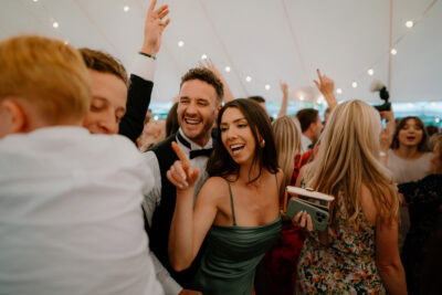 Lively wedding dance floor with laughing guests.