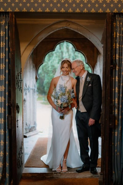 Bride and father entering church for wedding ceremony.