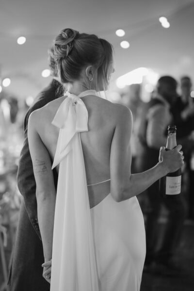 Bride holding champagne at wedding reception.