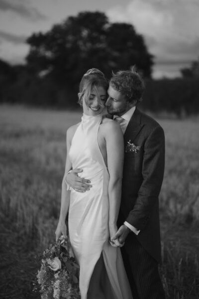 Couple embracing in a field during wedding