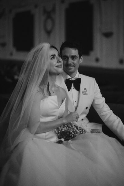 Smiling bride and groom sitting closely together.
