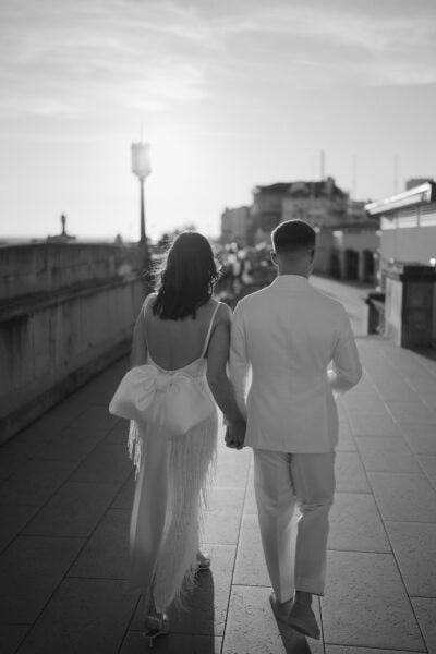 Couple walking in elegant attire during sunset.