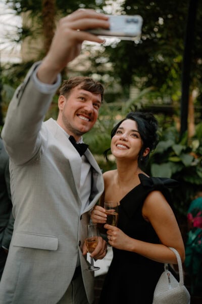 Couple taking selfie at outdoor event with drinks