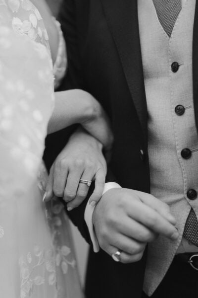 Close-up of bride and groom's interlocking hands.