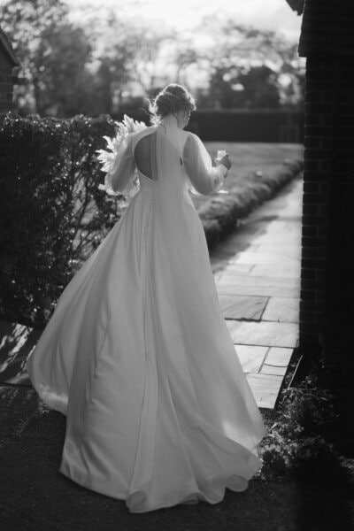 Bride walking in elegant gown, holding bouquet