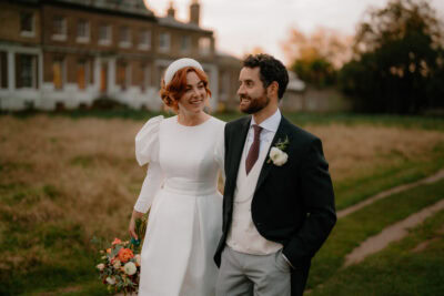 Happy couple walking outside on wedding day.