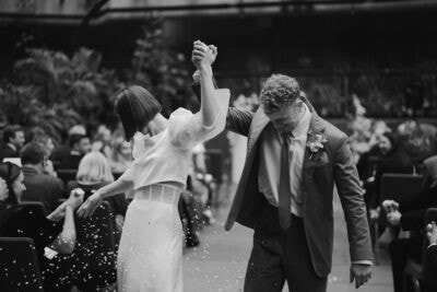 Couple joyfully walking down the wedding aisle.
