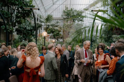 People socialising at indoor garden event.