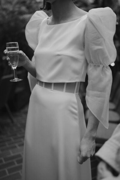 Woman in elegant white dress holding champagne glass.